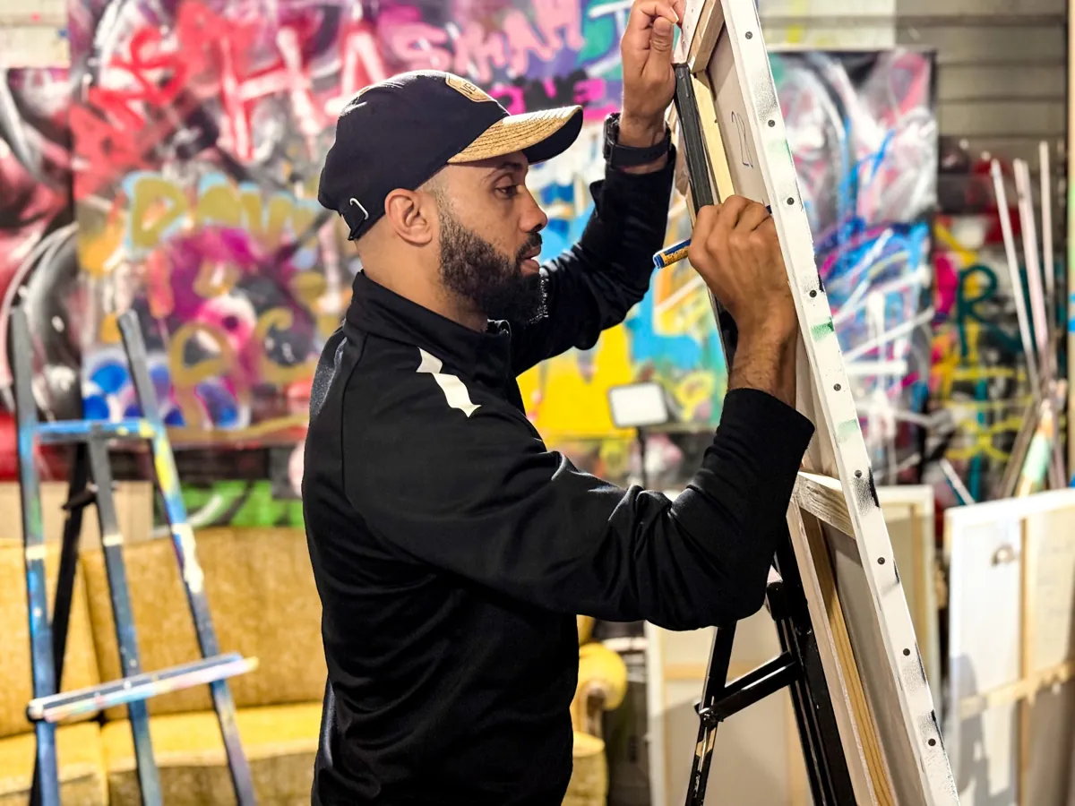 Un participant dessine sur une grande toile dans l'atelier